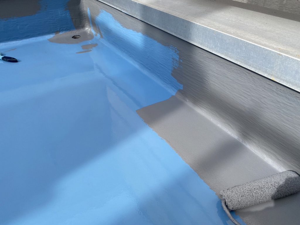 守山区でベランダ防水のトップコートを施工している様子